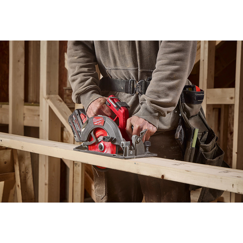 Person using a Milwaukee circular saw on a wooden plank in a construction setting