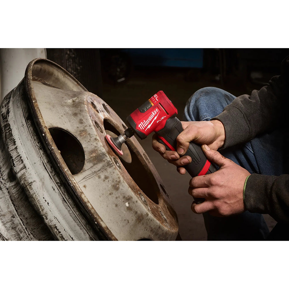 Person using a M12 FUEL™ 1/4" Right Angle Die Grinder on a tire in a workshop setting