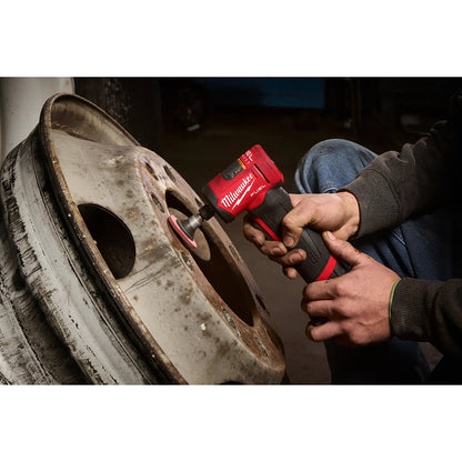 Person using a M12 FUEL™ 1/4" Right Angle Die Grinder on a tire in a workshop setting