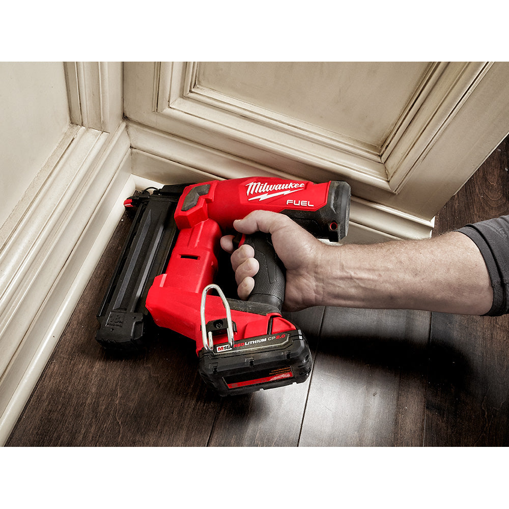 Person using a M18 FUEL™ 18 Gauge Brad Nailer on a wooden floor.