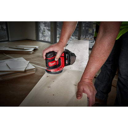 Person using a M18™ Random Orbit Sander on a wooden surface.