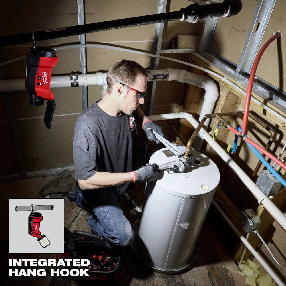 Person working on a water heater with a tool, wearing safety glasses and gloves, in a plumbing setting.