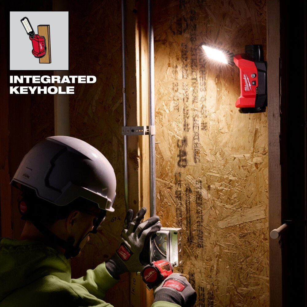 Person using a tool with an integrated keyhole on a wooden wall.