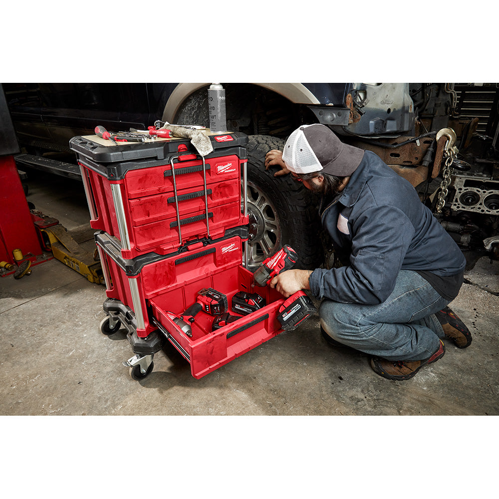 Person using a PACKOUT™ 2-Drawer Tool Box in a garage setting
