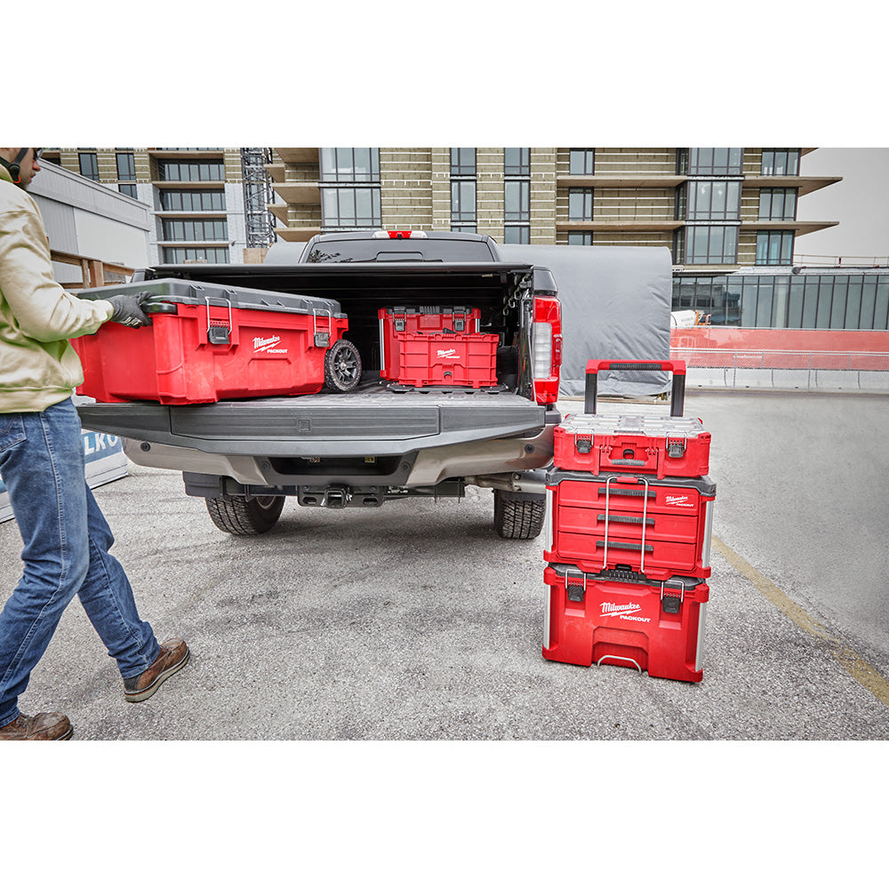 Person loading PACKOUT™ 3-Drawer Tool Box into the back of a truck in an urban setting.