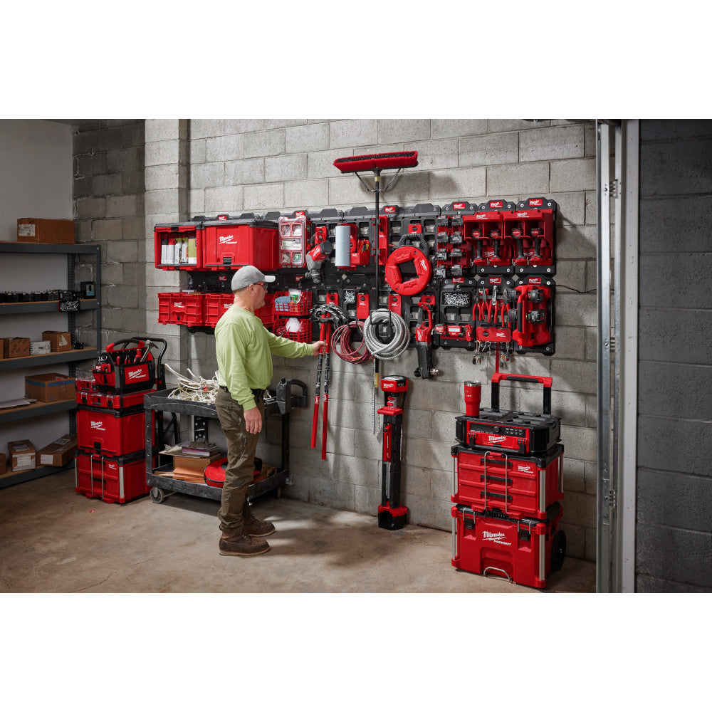 Man organizing tools in a garage with PACKOUT storage solutions.