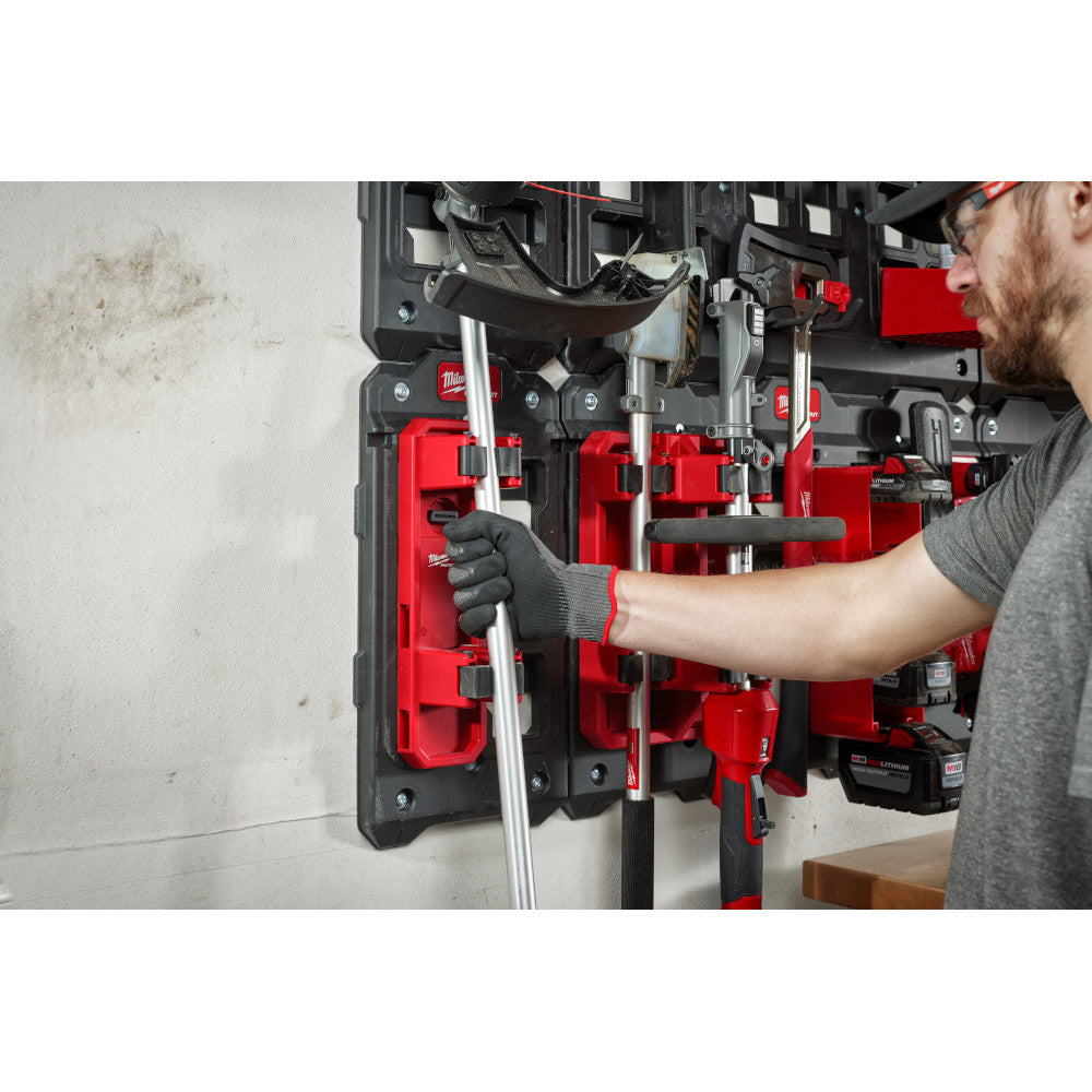 Person using a tool holder with various tools in a workshop setting.