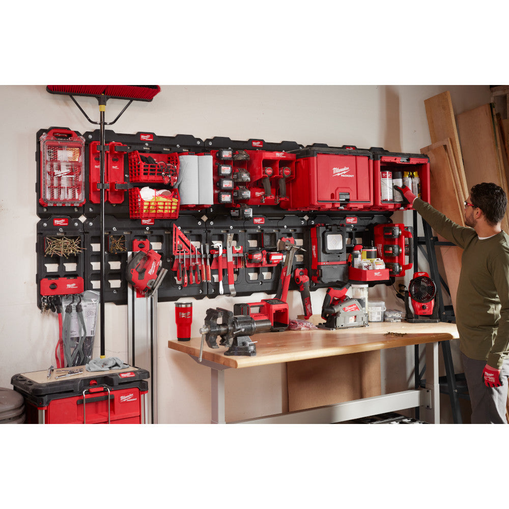Person organizing tools in a PACKOUT storage system in a workshop.