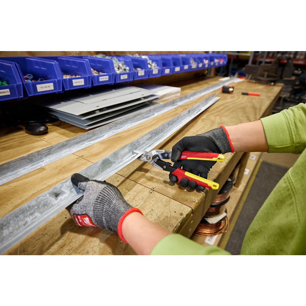 Person using pliers on metal strips with a workshop background